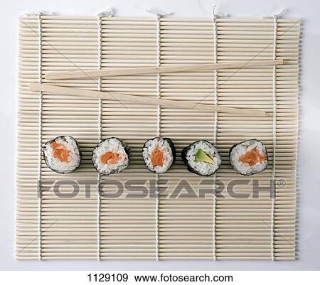 Stock Photo - Sushi and chopsticks on a wooden mat. Fotosearch