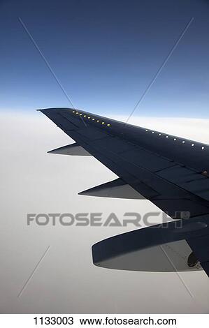 The wing of an airplane in mid-air View Large Photo Image Stock Image - The wing of an airplane in mid-air. Fotosearch