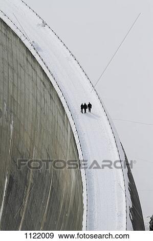 Three people walking above the Zervreila Dam, Switzerland View Large Photo Image Stock Photo - Three people walking above the Zervreila Dam, Switzerland. Fotosearch