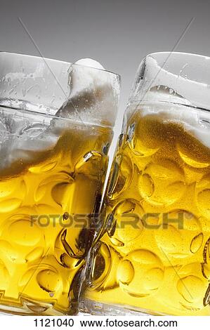Toasting with two glasses of beer View Large Photo Image Stock Image - Toasting with two glasses of beer. Fotosearch