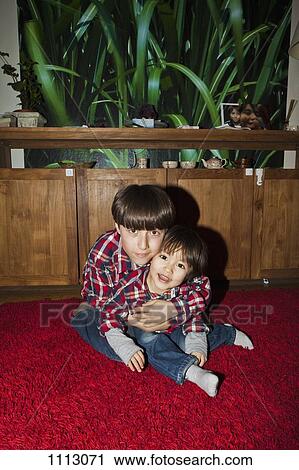 Two brothers in matching outfits embracing View Large Photo Image Stock Image - Two brothers in matching outfits embracing. Fotosearch