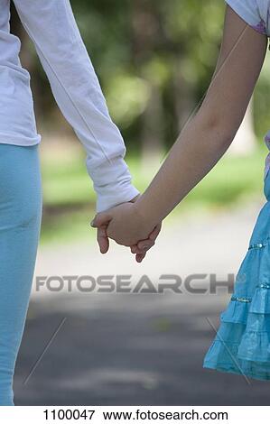 Stock Photo - Two girls holding hands. Fotosearch