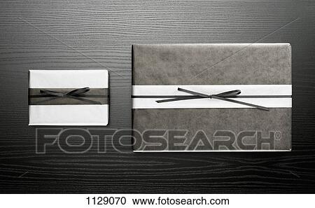 Two wrapped presents on a wooden table View Large Photo Image Stock Image - Two wrapped presents on a wooden table. Fotosearch