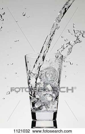 Stock Image - Water being poured into a glass. Fotosearch