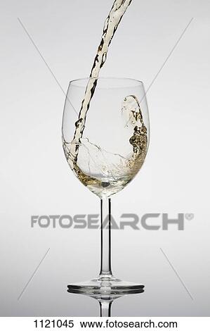 Stock Photography - White wine being poured into a glass. Fotosearch