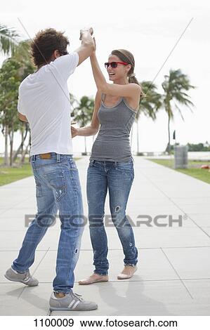 Young couple flirting on the promenade View Large Photo Image Stock Photo - Young couple flirting on the promenade. Fotosearch