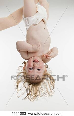 A baby girl held upside down View Large Photo Image Stock Image - A baby girl held upside down. Fotosearch