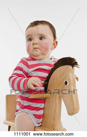 A baby girl on a rocking horse View Large Photo Image Stock Image - A baby girl on a rocking horse. Fotosearch