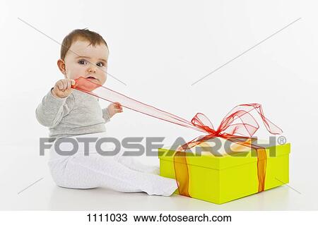 A baby girl opening a present View Large Photo Image Stock Image - A baby girl opening a present. Fotosearch