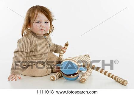 A baby girl sitting with a stuffed toy View Large Photo Image Stock Photo - A baby girl sitting with a stuffed toy. Fotosearch