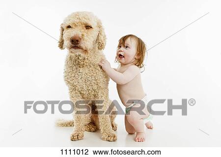 Stock Image - A baby girl with a dog. Fotosearch