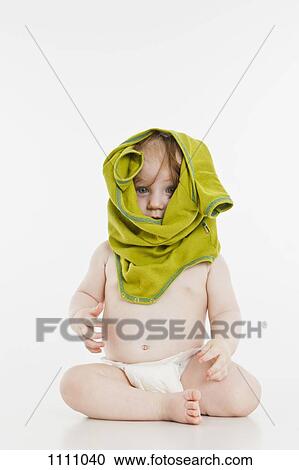 Stock Image - A baby girl with clothing on her head. Fotosearch