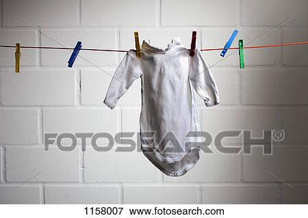 A baby's onesie hanging from a clothesline View Large Photo Image Stock Photo - A baby's onesie hanging from a clothesline . Fotosearch