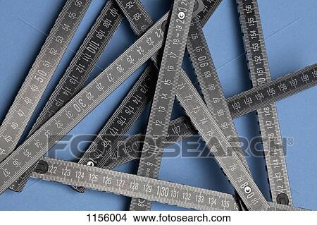 A black folding ruler on a blue background View Large Photo Image Picture - A black folding ruler on a blue background. Fotosearch