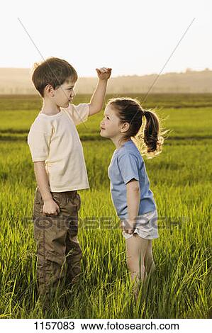 A boy and a girl in a field comparing heights View Large Photo Image Stock Image - A boy and a girl in a field comparing heights. Fotosearch