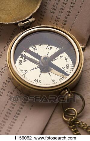 A brass pocket compass on top of the financial page of a newspaper View Large Photo Image Stock Image - A brass pocket compass on top of the financial page of a newspaper. Fotosearch