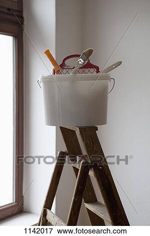 A bucket of painting equipment on a ladder View Large Photo Image Stock Photo - A bucket of painting equipment on a ladder. Fotosearch
