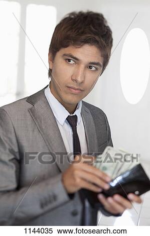 Stock Photography - A businessman taking money out of his wallet. Fotosearch