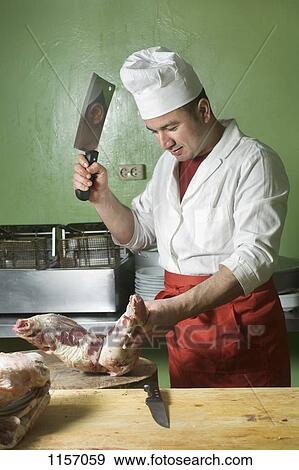 A butcher chopping meat with a cleaver View Large Photo Image Stock Photo - A butcher chopping meat with a cleaver. Fotosearch