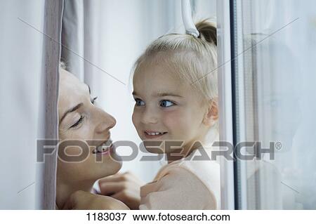 Stock Photo - A cheerful mother and her young daughter, face to face. Fotosearch