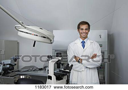 Stock Photo - A cheerful research technician standing in a research lab, arms crossed. Fotosearch