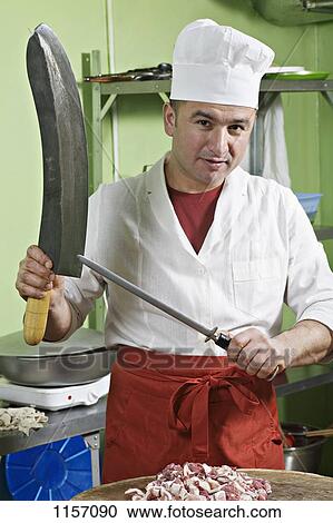 A chef sharpening a large knife View Large Photo Image Stock Image - A chef sharpening a large knife. Fotosearch