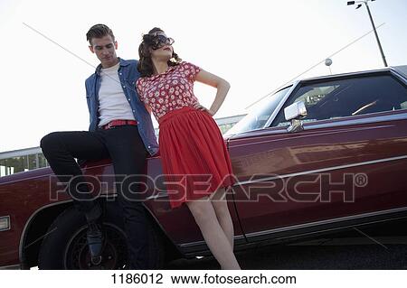 A cool, rockabilly couple leaning against a vintage car View Large Photo Image Stock Image - A cool, rockabilly couple leaning against a vintage car. Fotosearch