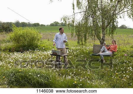 A couple barbecuing in their backyard, rural setting View Large Photo Image Stock Photo - A couple barbecuing in their backyard, rural setting. Fotosearch