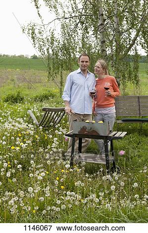 A couple barbecuing in their backyard, rural setting View Large Photo Image Stock Photo - A couple barbecuing in their backyard, rural setting. Fotosearch