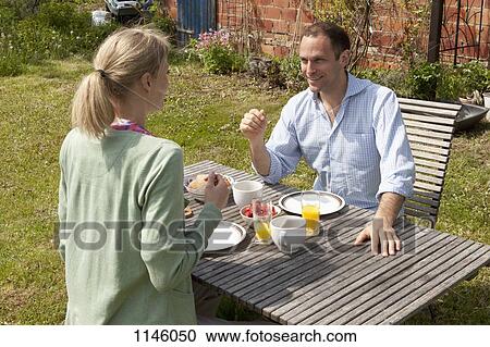 A couple enjoying breakfast in their backyard View Large Photo Image Stock Image - A couple enjoying breakfast in their backyard. Fotosearch