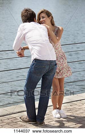 A couple enjoying time by a lake View Large Photo Image Stock Photo - A couple enjoying time by a lake. Fotosearch