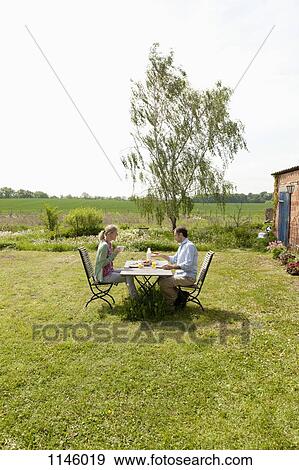 A couple having breakfast in their backyard View Large Photo Image Stock Photo - A couple having breakfast in their backyard. Fotosearch