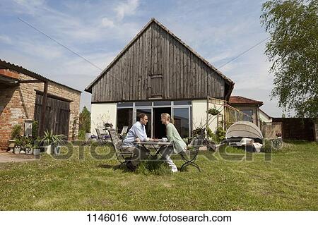 A couple having breakfast in their backyard View Large Photo Image Stock Photograph - A couple having breakfast in their backyard. Fotosearch