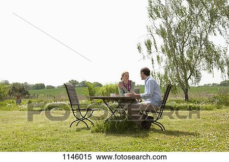 Stock Photography - A couple having breakfast in their backyard. Fotosearch