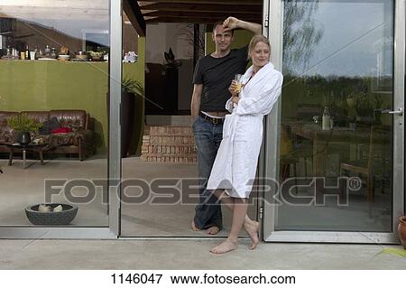 A couple leaning against the doorway of their house in the morning View Large Photo Image Stock Photo - A couple leaning against the doorway of their house in the morning. Fotosearch