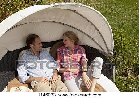A couple reclining in a cabana in their backyard View Large Photo Image Stock Image - A couple reclining in a cabana in their backyard. Fotosearch