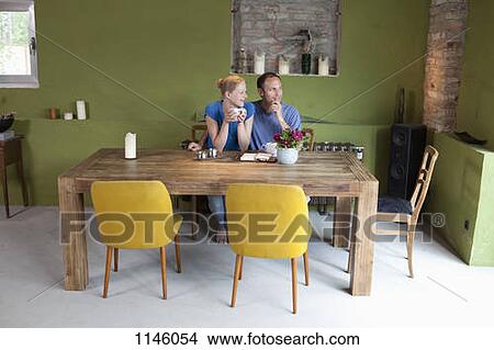 A couple with a personal organizer and coffee, looking contemplative View Large Photo Image Picture - A couple with a personal organizer and coffee, looking contemplative. Fotosearch