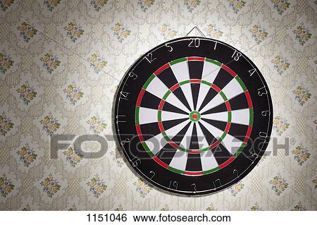 A dartboard hanging on a wallpapered wall View Large Photo Image Stock Photograph - A dartboard hanging on a wallpapered wall. Fotosearch