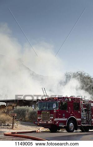 A fire truck next to a burning house in a suburb View Large Photo Image Stock Photography - A fire truck next to a burning house in a suburb. Fotosearch