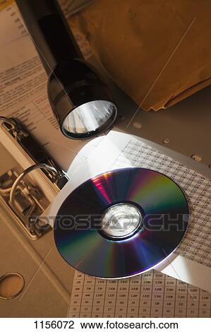 A flashlight illuminating a compact disc on top of a spreadsheet and binder View Large Photo Image Stock Image - A flashlight illuminating a compact disc on top of a spreadsheet and binder. Fotosearch