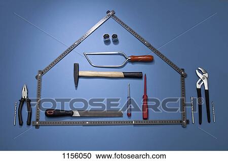 Stock Image - A folding ruler arranged to look like a house with various work tools. Fotosearch