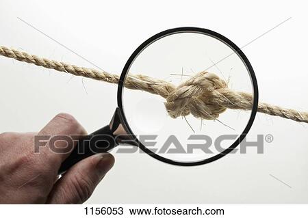 A hand holding a magnifying glass magnifying a knot in a rope View Large Photo Image Stock Image - A hand holding a magnifying glass magnifying a knot in a rope. Fotosearch