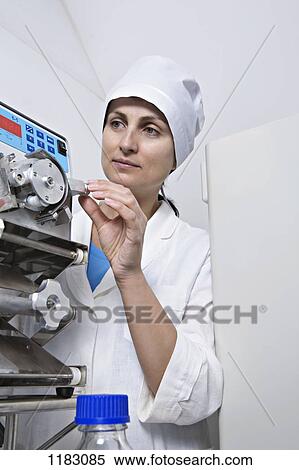 Stock Photography - A lab technician adjust a knob on diagnostic medical equipment. Fotosearch