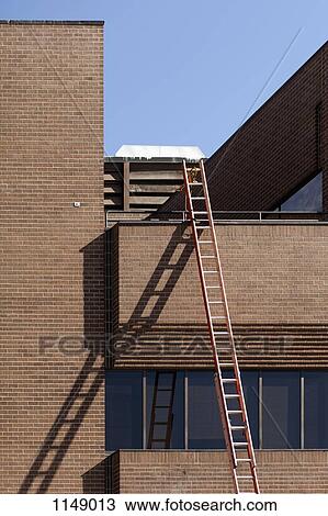 A ladder leaning against a building View Large Photo Image Stock Image - A ladder leaning against a building. Fotosearch