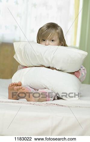 A little girl looking sad while squeezing a pillow View Large Photo Image Stock Image - A little girl looking sad while squeezing a pillow. Fotosearch