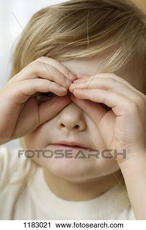 Stock Image - A little girl looking through glasses made from her fingers. Fotosearch