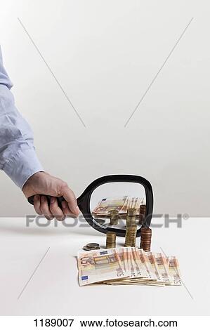 A man holding a hand mirror up to a pile of European Union currency View Large Photo Image Stock Photo - A man holding a hand mirror up to a pile of European Union currency. Fotosearch