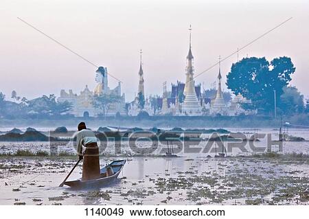 A man rowing a boat towards a temple in Burma View Large Photo Image Stock Photo - A man rowing a boat towards a temple in Burma. Fotosearch