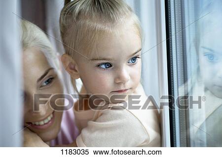 A mother and daughter looking out a window View Large Photo Image Stock Photography - A mother and daughter looking out a window. Fotosearch