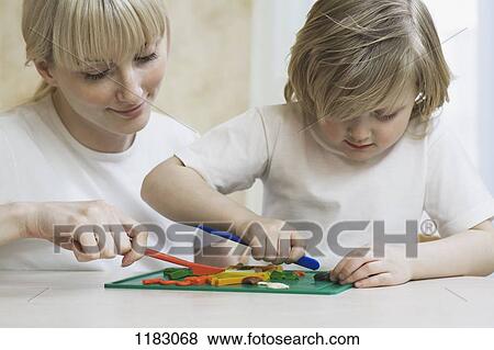 Stock Photo - A mother and her young daughter playing with child's play clay. Fotosearch